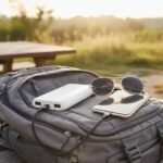 ERD PB-10KE 10000mAh Power Bank charging a smartphone outdoors on a backpack.